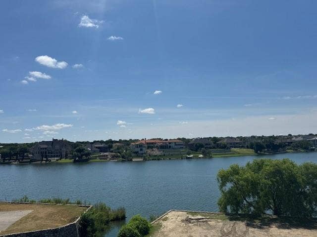 Waterfront setting featuring a broad expanse of water and a distant treelined shore with residential properties