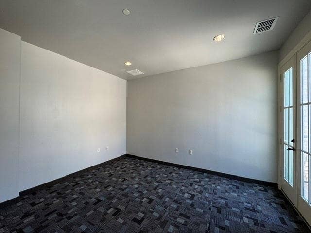 Recessed lighting, patterned carpet flooring, and a French door with multiple glass panes