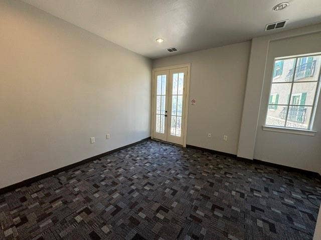 Recessed lighting, patterned carpet flooring, and a window with exterior architectural details