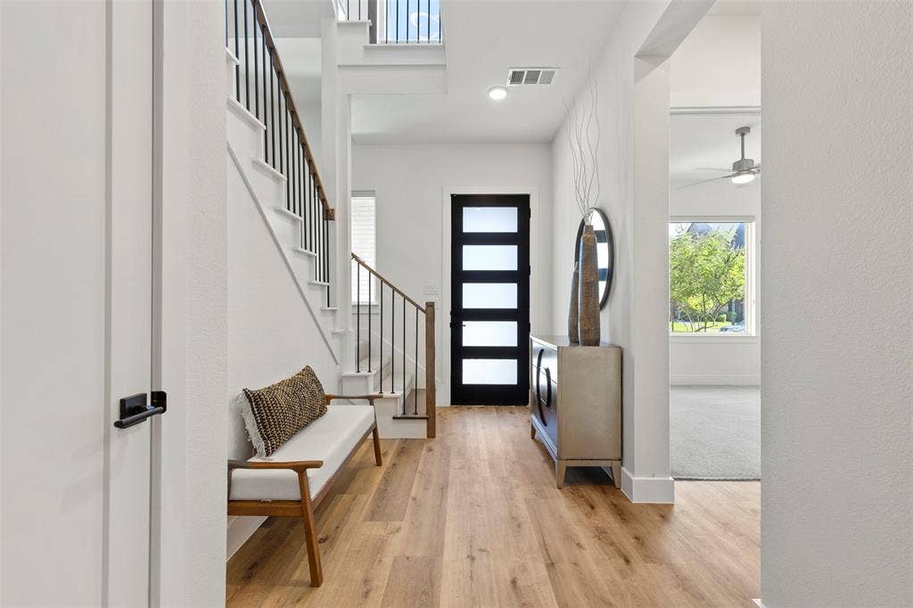 This home features newly installed luxury vinyl flooring throughout the entire first level, providing a modern, durable, and seamless look, complemented by a beautiful, high-quality upgraded wood front door that adds immediate curb appeal and elegance to the entrance.