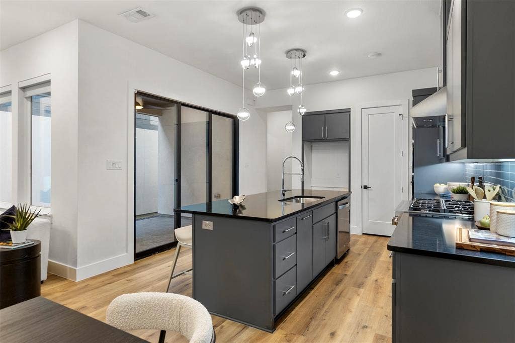 The gourmet kitchen seamlessly transitions into a spacious outdoor patio, creating an expansive flow that perfectly extends your primary living and entertaining area into the beautiful open air.