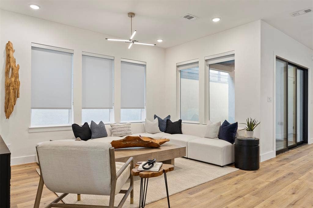 Natural light fills this living space, highlighting the spacious open-concept floor plan and the warm, neutral color palette that complements the home's contemporary finishes.