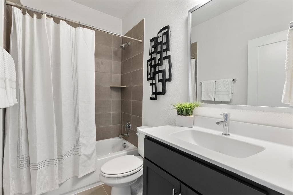 Well-appointed secondary bathroom that includes modern fixtures, ample vanity storage, and tasteful finishes throughout, providing a comfortable space for family and guests alike.