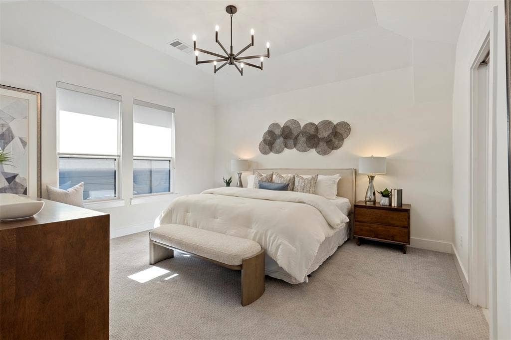 This primary bedroom suite features a remarkably spacious and open floor plan, complemented by high-end ensuite facilities and luxury finishes designed to offer a serene and private retreat within the home.