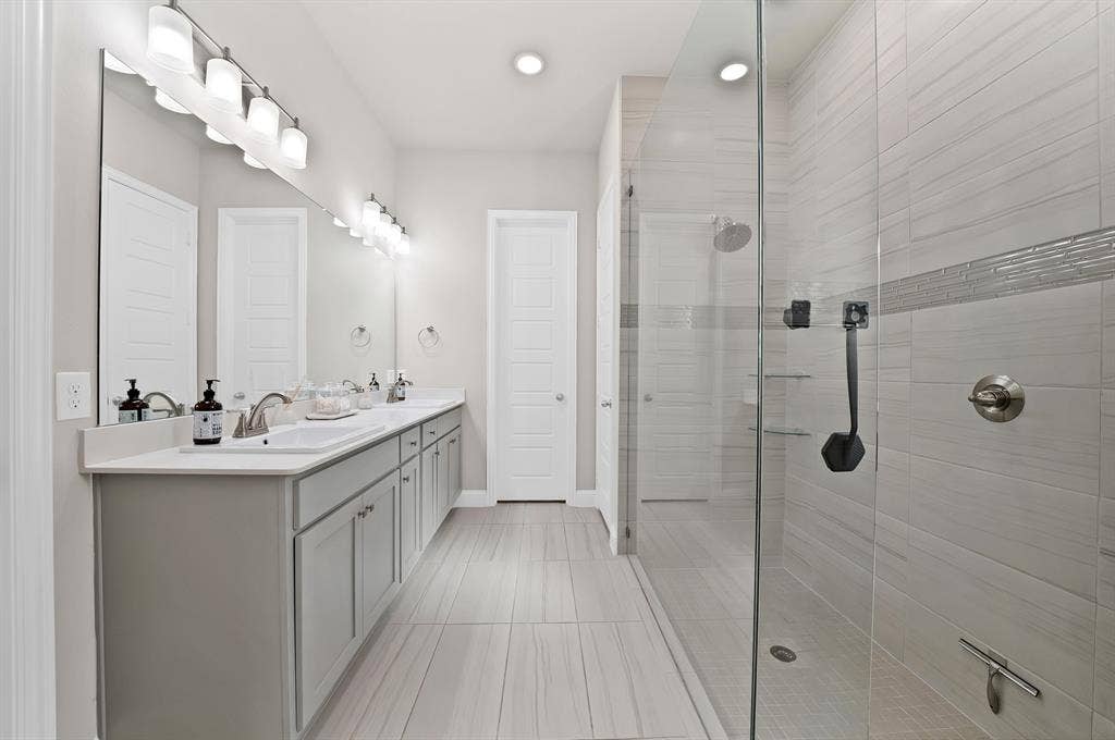 1837 Averi Lane, Farmers Branch, TX 75234 Dual vanity with undermount sinks, light gray cabinetry, and a full-width mirror