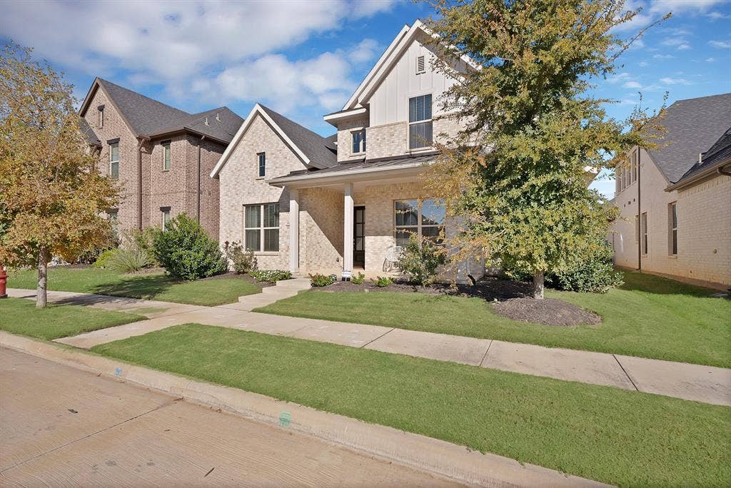 1837 Averi Lane, Farmers Branch, TX 75234 Two-story residence featuring light-colored brick and siding accents