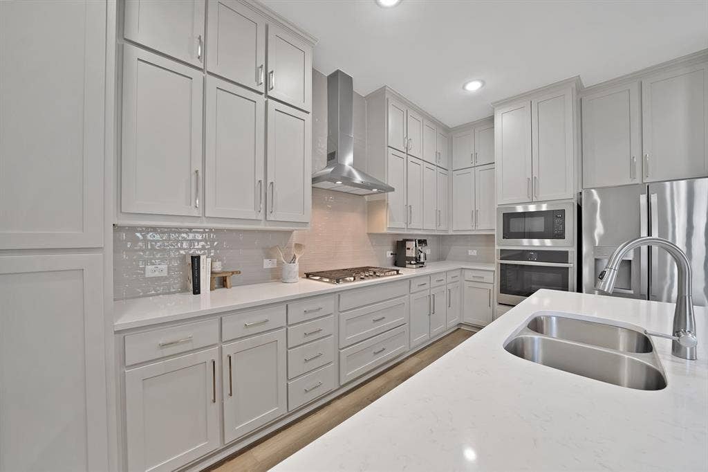 1837 Averi Lane, Farmers Branch, TX 75234 Expansive kitchen featuring abundant cabinetry, stainless steel appliances, a double basin sink, and light-toned countertops