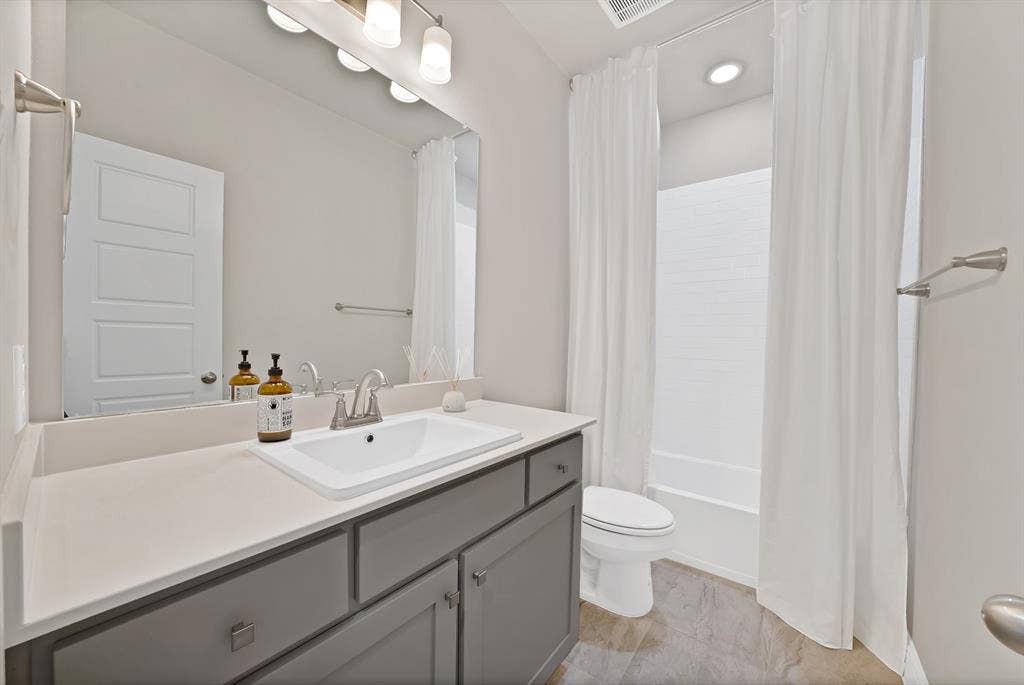1837 Averi Lane, Farmers Branch, TX 75234 Vanity with an integrated rectangular sink, gray cabinetry, and a light-toned countertop
