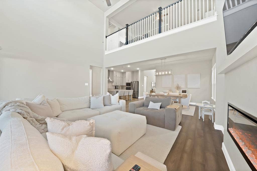 1837 Averi Lane, Farmers Branch, TX 75234 Two-story living area with high ceilings, wood-finish flooring, and an upper-level railing overlooking the space
