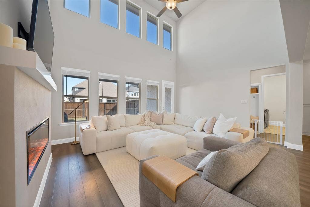 1837 Averi Lane, Farmers Branch, TX 75234 Two-story living area with high ceilings, dark wood-finish flooring, and an electric fireplace
