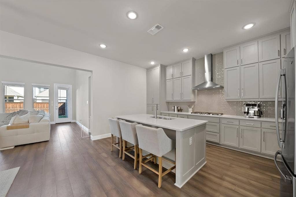 1837 Averi Lane, Farmers Branch, TX 75234 Recessed lighting throughout, wood-finish flooring, kitchen island with seating, stainless steel appliances, and extensive cabinetry