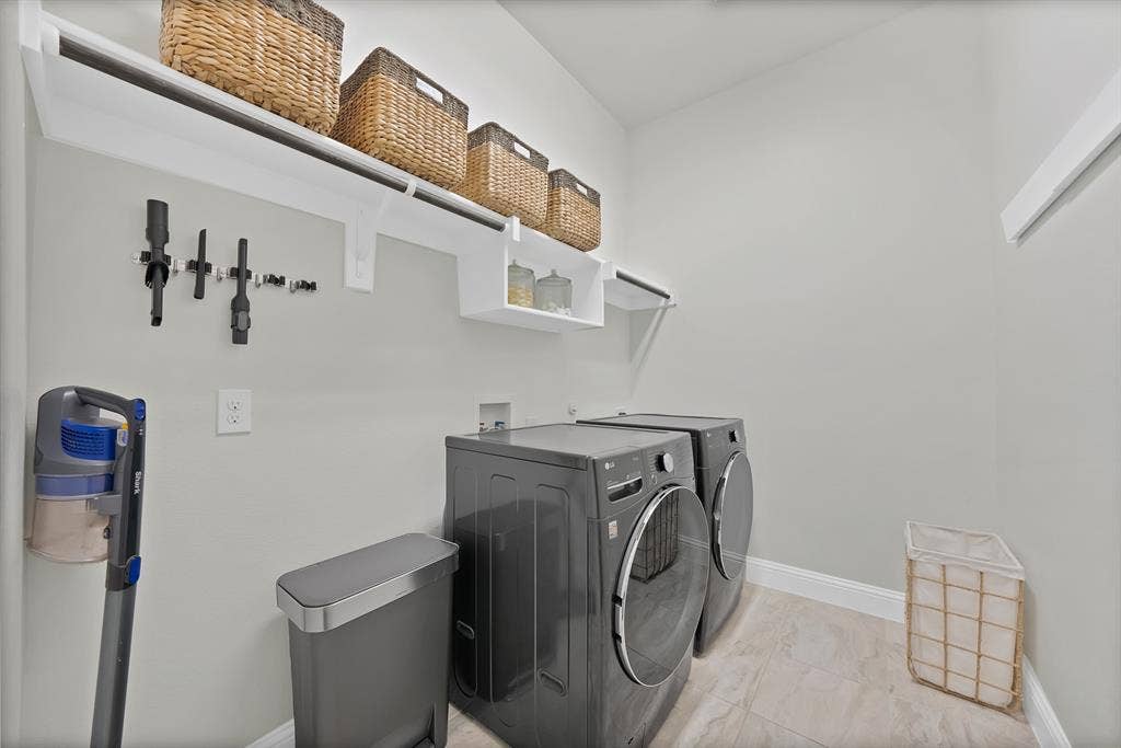 1837 Averi Lane, Farmers Branch, TX 75234 Integrated laundry area featuring neutral-toned walls, tile flooring, and white shelving with a hanging rod