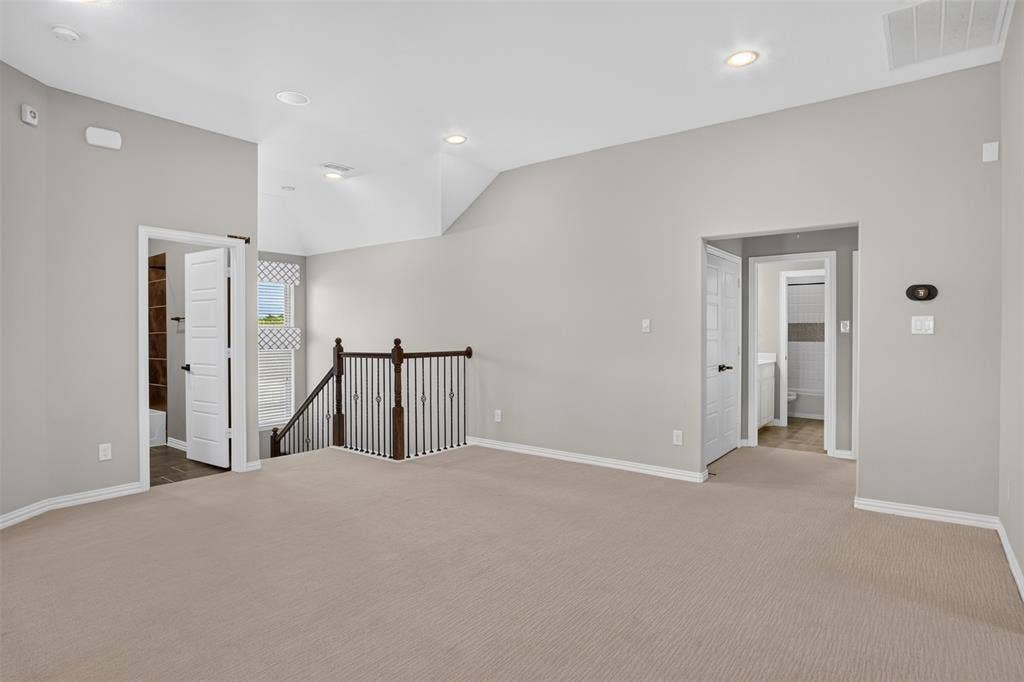 702 Callaway Drive, Allen, TX 75013 Vaulted ceiling with recessed lighting, carpet flooring, and a dark wood and wrought iron staircase railing