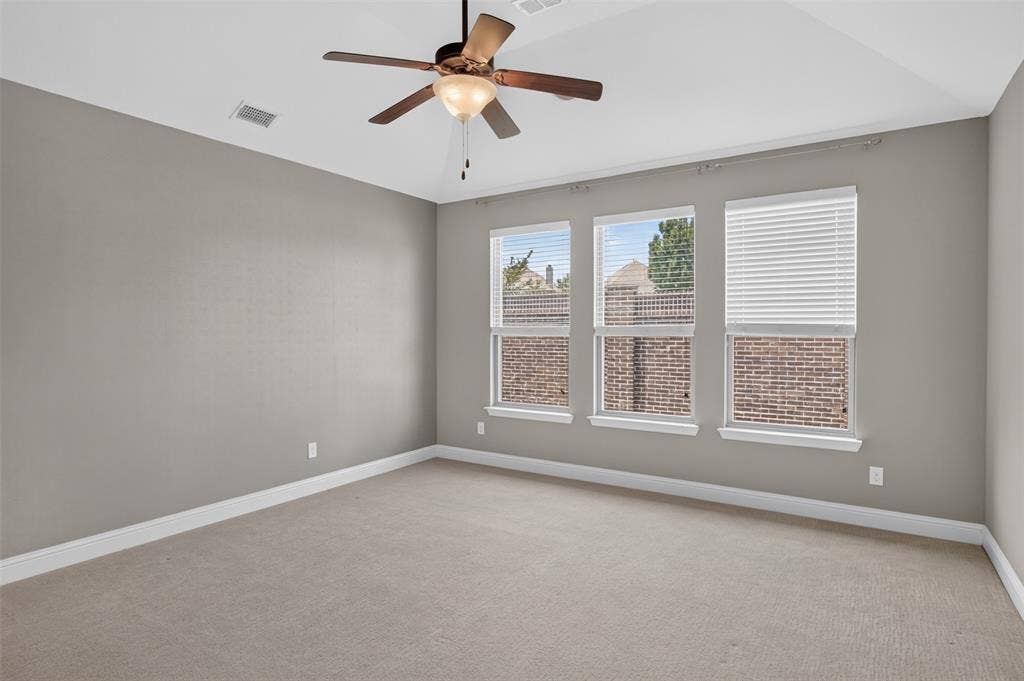 702 Callaway Drive, Allen, TX 75013 Carpeted room featuring three windows with blinds, a ceiling fan, and tray ceiling