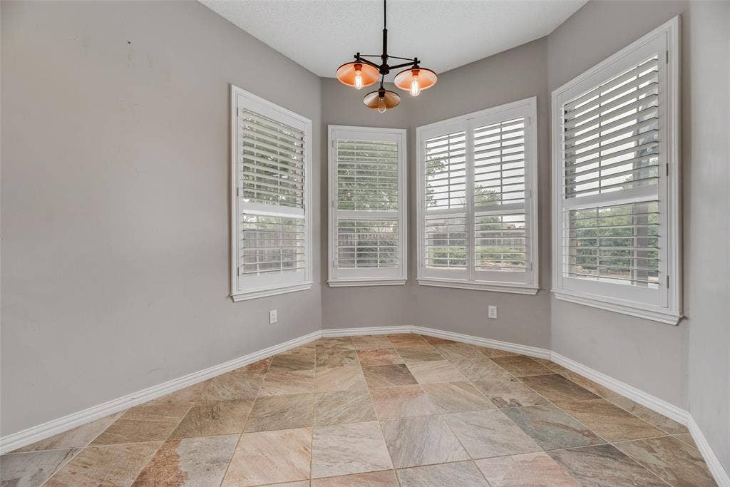 Bay window with plantation shutters and a contemporary pendant light fixture