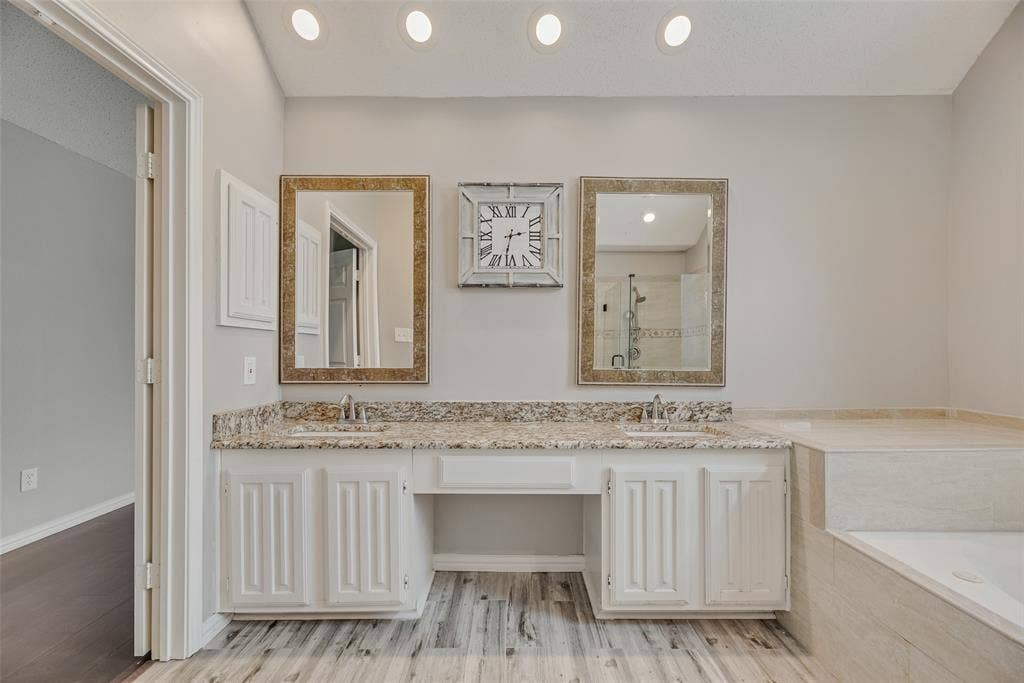 Dual vanities with polished chrome fixtures and stone countertops