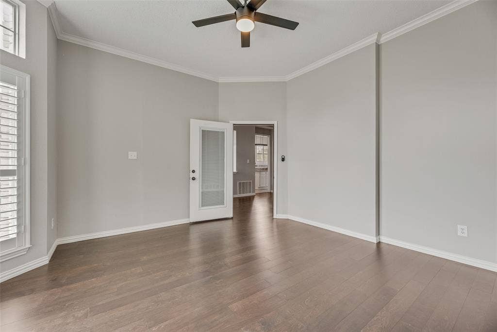 Hardwood flooring, crown molding, white plantation shutters, and a ceiling fan with integrated lighting