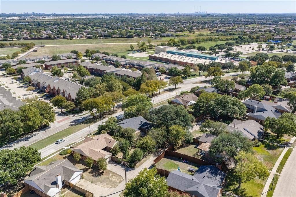Residential neighborhood featuring single-story homes, mature trees, and paved roads