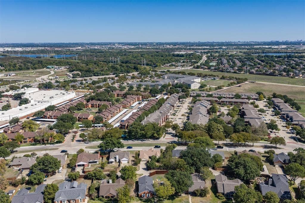 Aerial perspective showcasing a residential community with varied rooflines and extensive tree canopy
