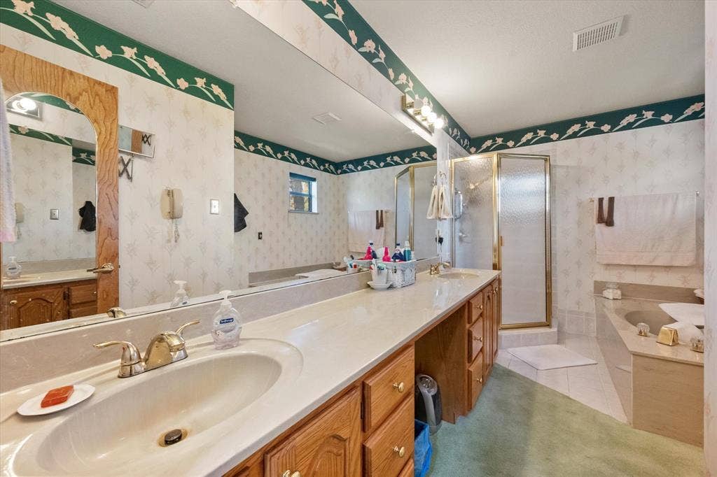 5203 Thunderbird Trail, De Cordova, TX 76049 Dual vanity with wood-finish cabinetry, a built-in shower, an integrated tub, and a large wall-mounted mirror