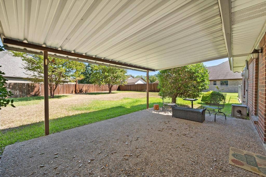 5203 Thunderbird Trail, De Cordova, TX 76049 Expansive backyard featuring a covered patio, brick exterior, and mature trees