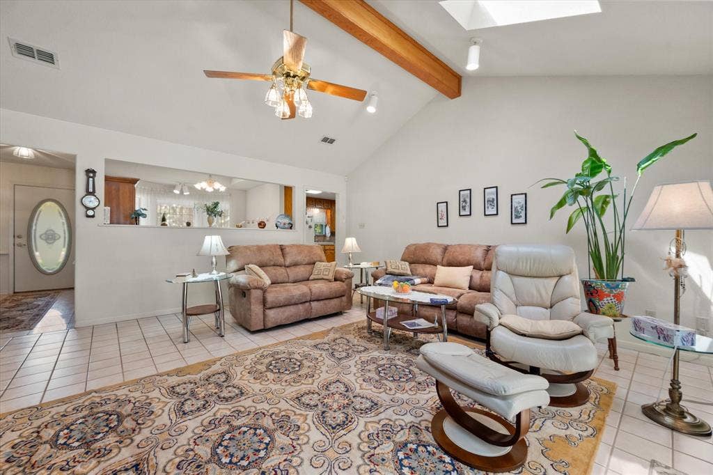 5203 Thunderbird Trail, De Cordova, TX 76049 Vaulted ceiling with exposed wood beams, skylight, and ceiling fan