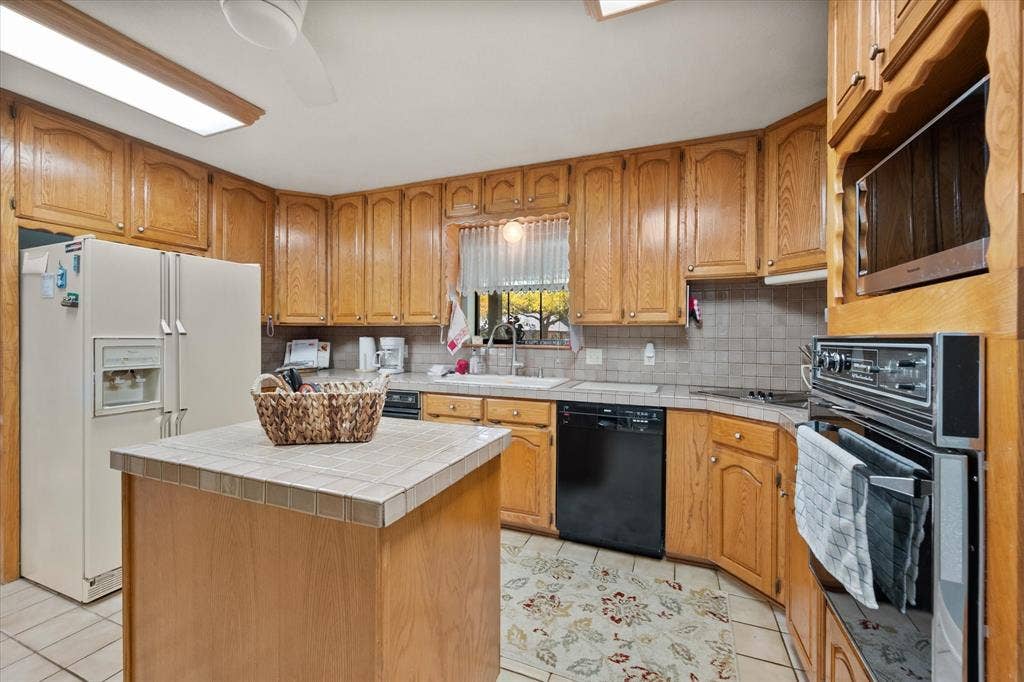 5203 Thunderbird Trail, De Cordova, TX 76049 Kitchen featuring wood-finish cabinetry, tile countertops, a built-in oven, and a built-in microwave