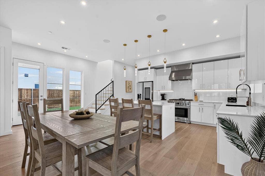 Gleaming kitchen with white cabinetry and stainless steel appliances
