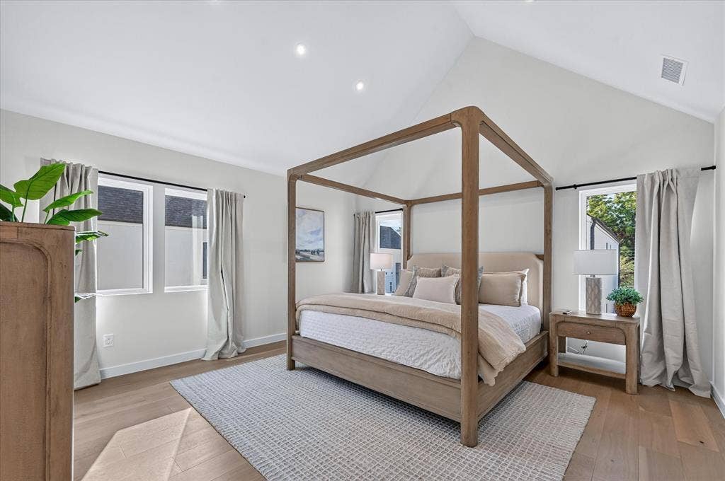 Vaulted ceiling, recessed lighting, wood-finish flooring, multiple windows, neutral wall tones