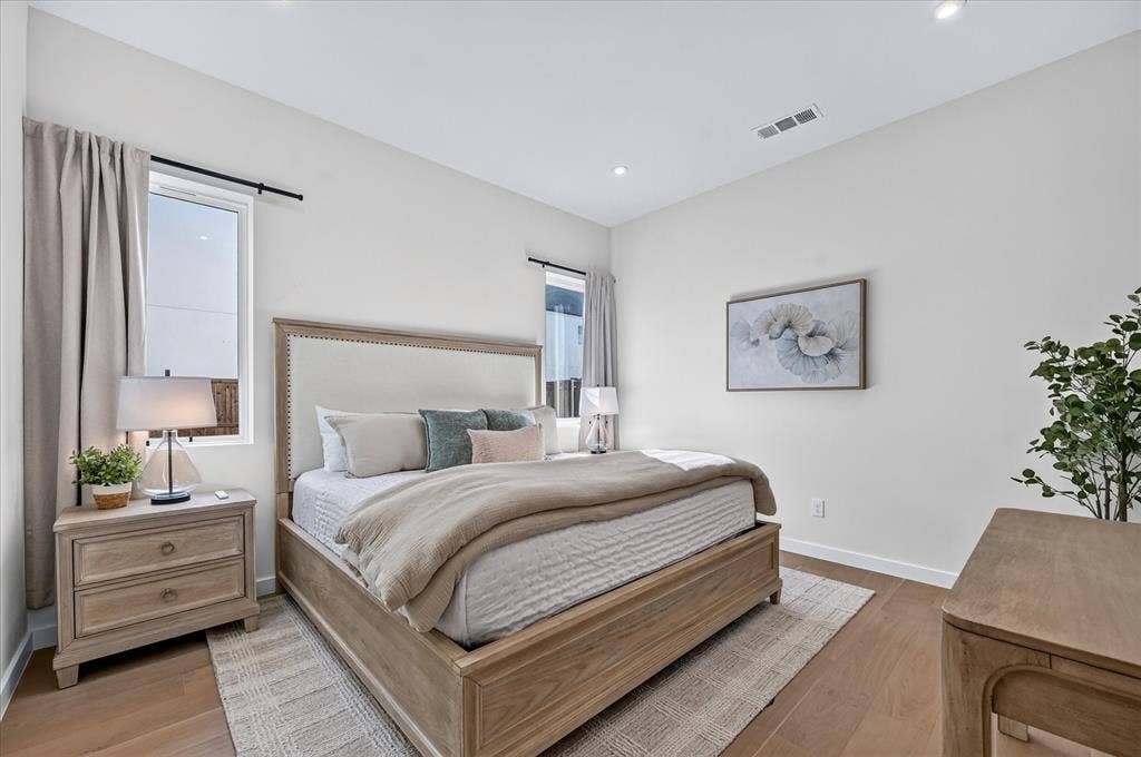Recessed lighting illuminates the space, featuring wood-finish flooring and light-colored walls
