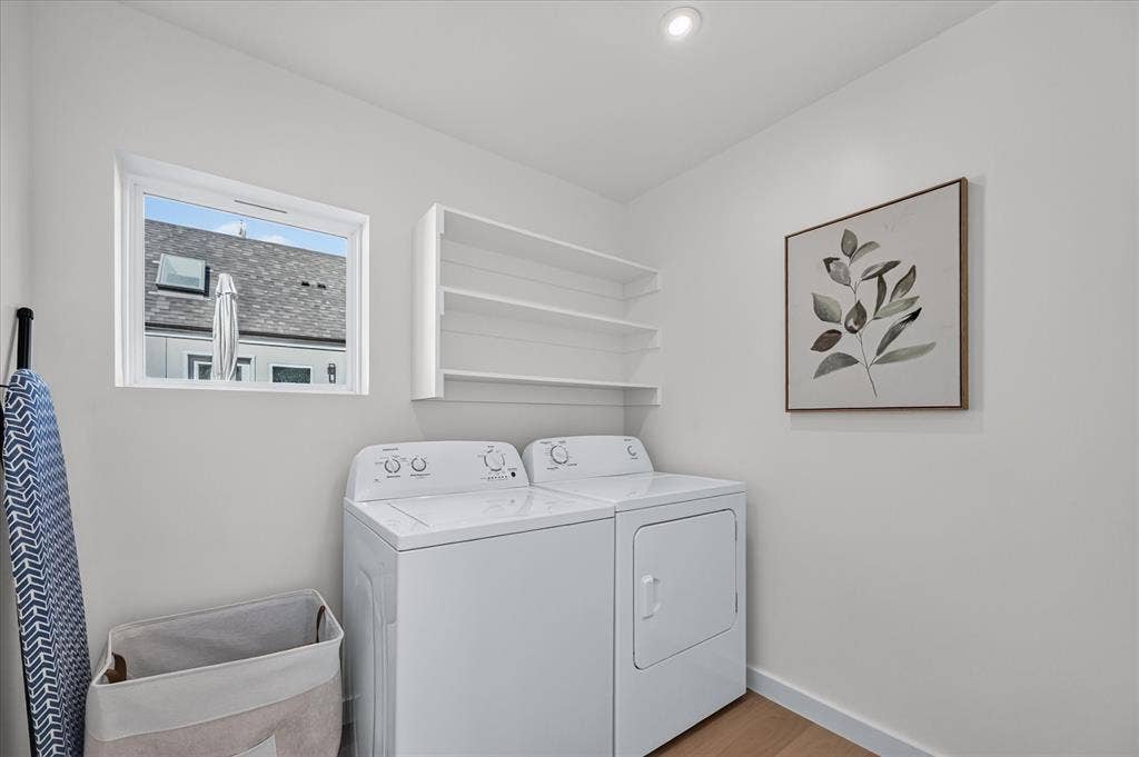 Laundry area featuring a window, built-in shelving, recessed lighting, and wood-finish flooring