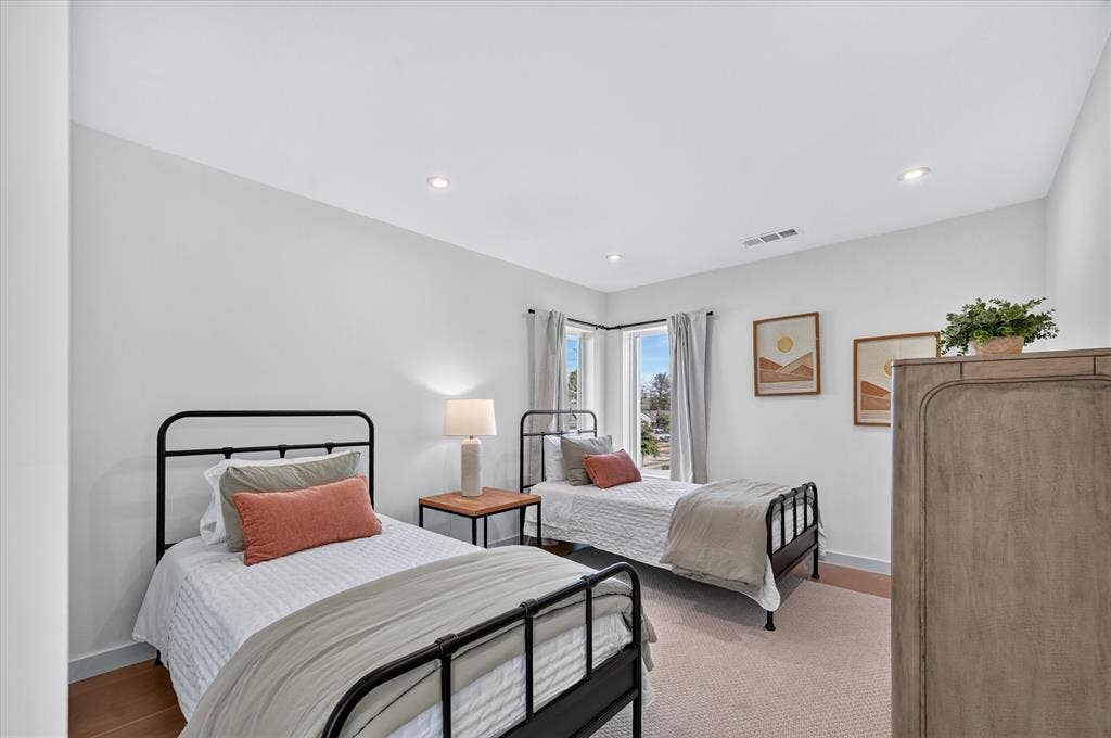 Recessed lighting illuminates the neutral wall tones and light-toned carpeting