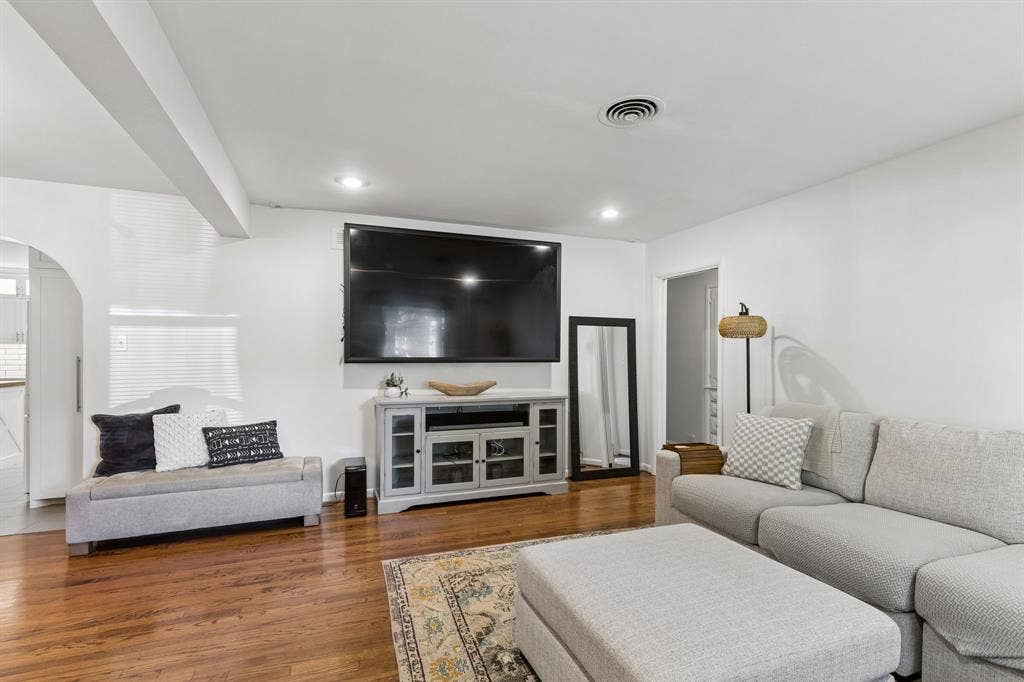 7230 Edgerton Drive, Dallas, TX 75231 Living area featuring wood-finish flooring, recessed lighting, and a distinctive arched doorway