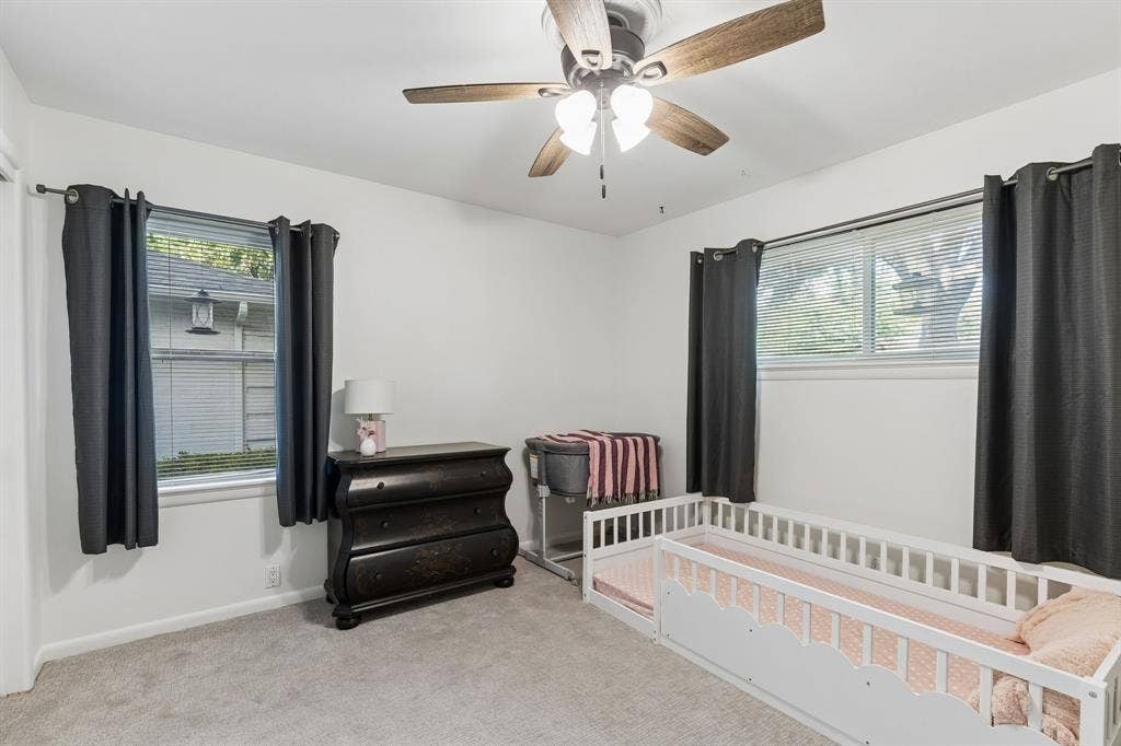 7230 Edgerton Drive, Dallas, TX 75231 Neutral-toned wall-to-wall carpeting, dual-aspect windows, and a ceiling-mounted light fixture with a multi-blade fan