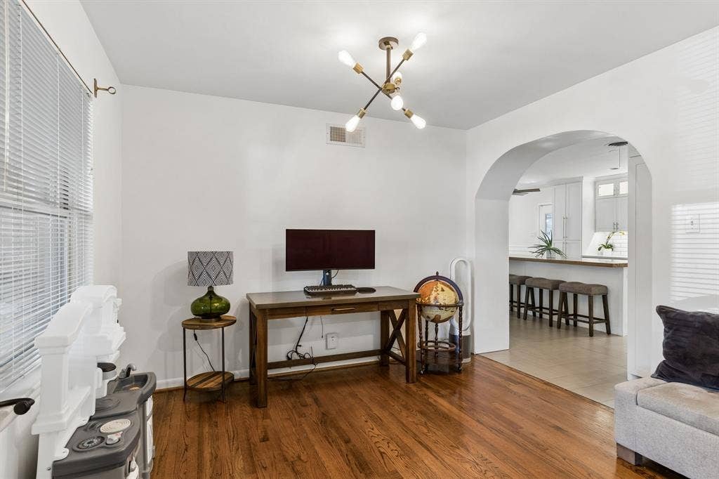 7230 Edgerton Drive, Dallas, TX 75231 Hardwood flooring, arched doorway, and multi-light industrial-style chandelier
