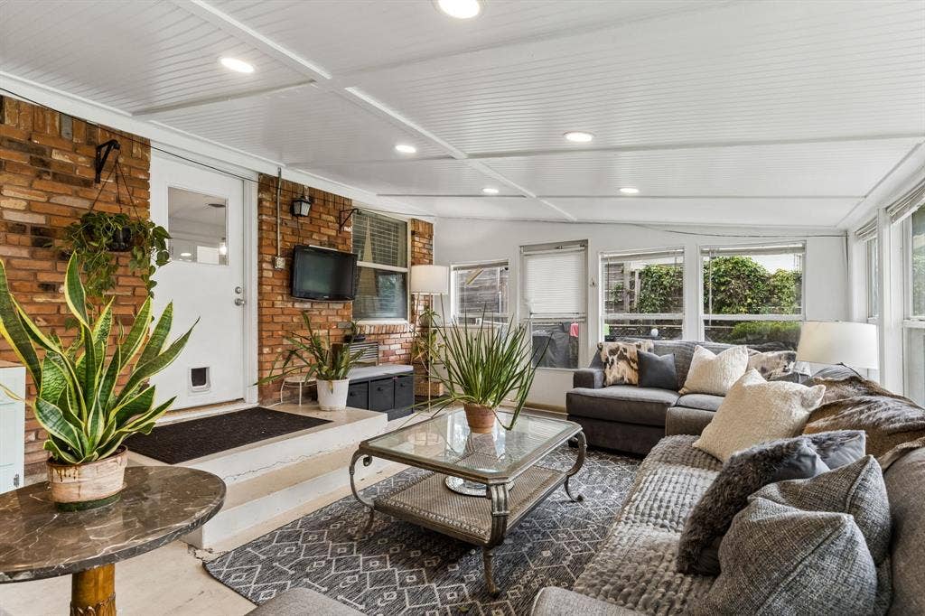 7230 Edgerton Drive, Dallas, TX 75231 Sunroom featuring exposed brick walls, a paneled ceiling with recessed lighting, and expansive windows