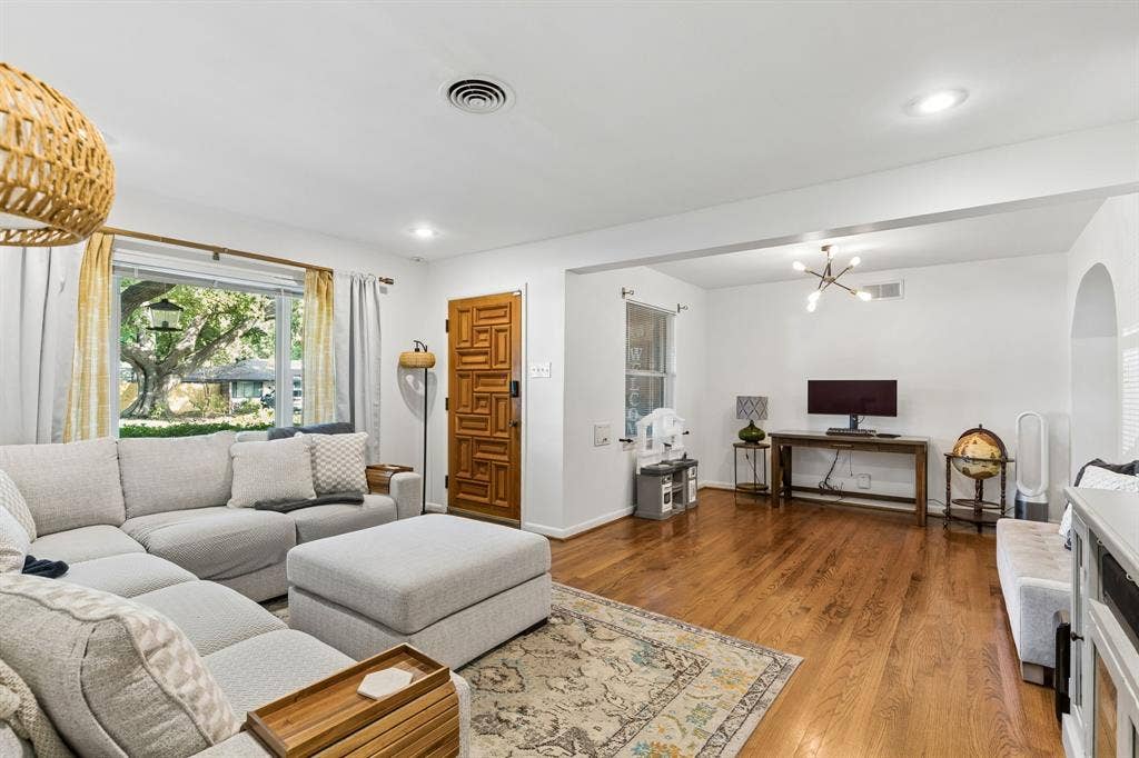 7230 Edgerton Drive, Dallas, TX 75231 Living space featuring hardwood flooring, natural wood geometric patterned front door, recessed lighting, and arched doorway