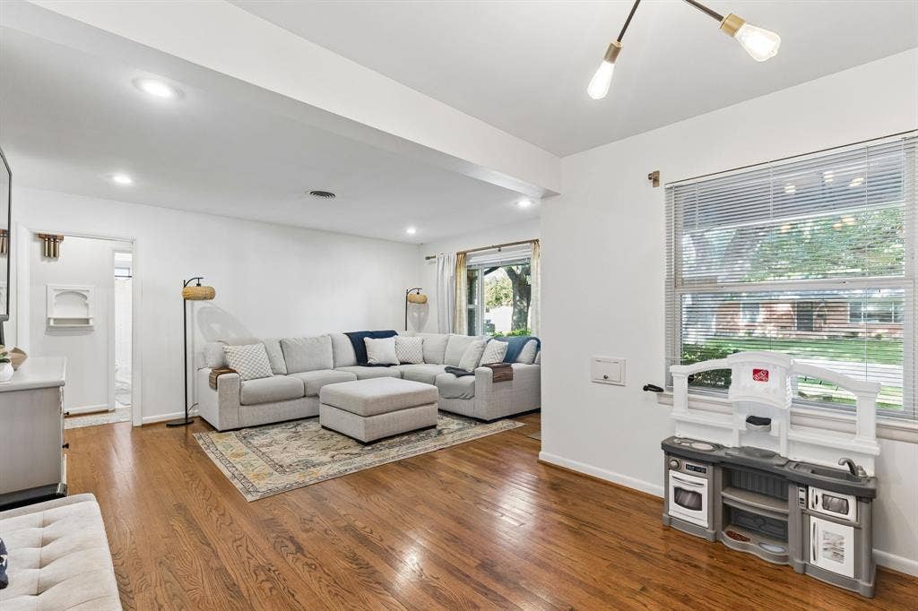 7230 Edgerton Drive, Dallas, TX 75231 Living area featuring wood-finish flooring, recessed lighting, a modern multi-arm ceiling fixture, and large windows with horizontal blinds