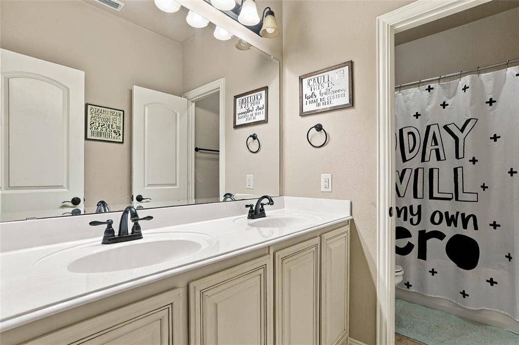 2820 Mariposa Drive, Grand Prairie, TX 75054 Bathroom with dual sinks, generous counter space, and storage.