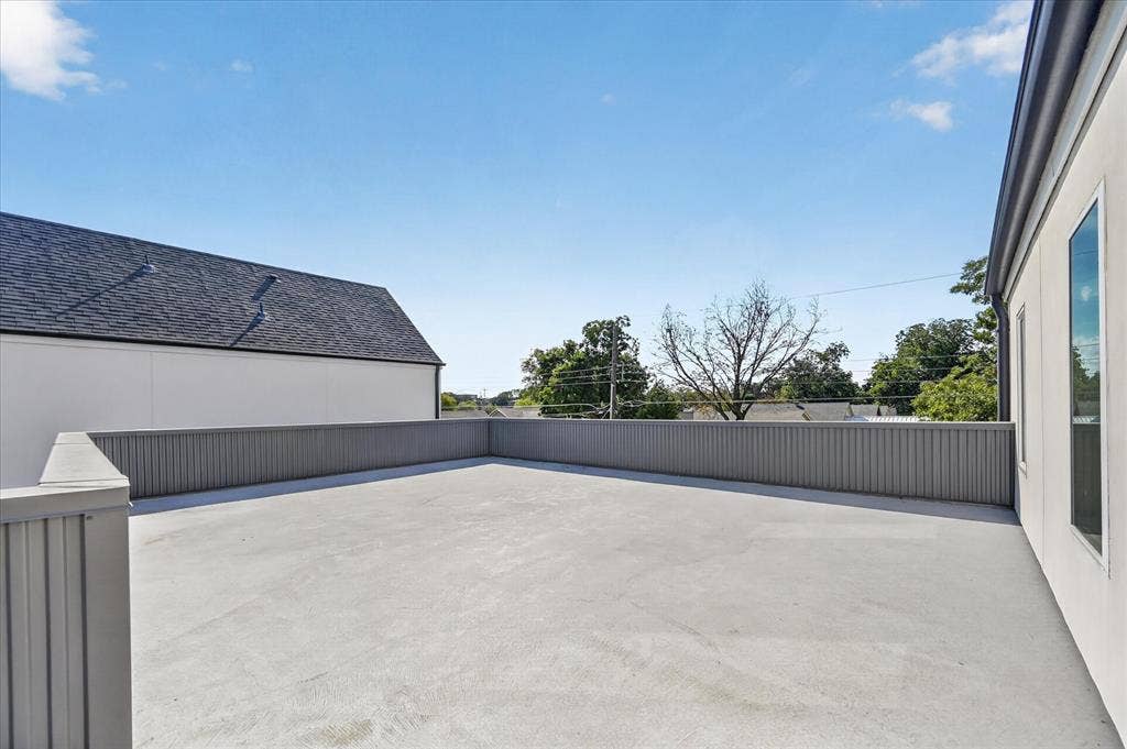 835 Nomas Street, Dallas, TX 75212 Expansive rooftop terrace with a durable concrete surface, full perimeter railing, and a windowed exterior wall