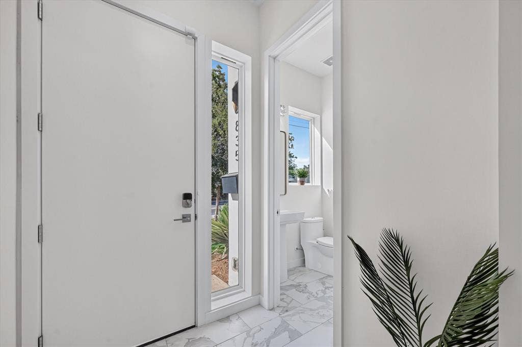835 Nomas Street, Dallas, TX 75212 Entryway featuring a white door with smart lock hardware, a full-length sidelight, and marble-finish tile flooring