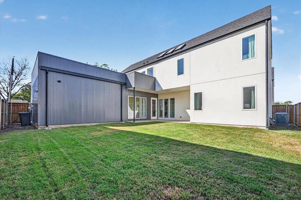 835 Nomas Street, Dallas, TX 75212 Expansive grassy yard with a modern white stucco exterior and dark corrugated metal siding