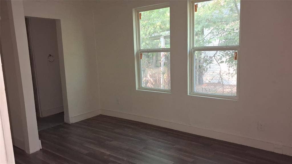 1224 Frost Avenue, Waco, TX 76708 Wood-finish flooring with white baseboards, white walls, and two windows