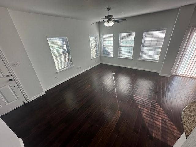 901 Brookville Court, Plano, TX 75074 Spacious room with dark wood-finish flooring, multiple windows, and a ceiling fan with integrated lighting