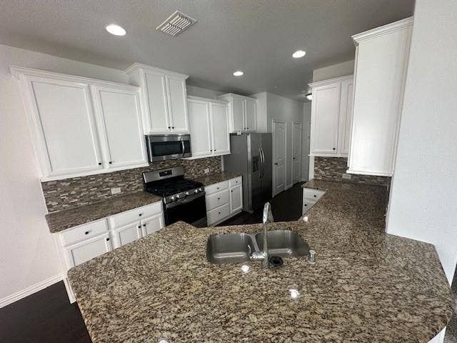 901 Brookville Court, Plano, TX 75074 Kitchen featuring white cabinetry, stone countertops, stainless steel appliances, a tile backsplash, and dark wood-finish flooring