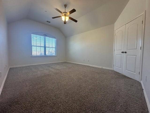 901 Brookville Court, Plano, TX 75074 Vaulted ceiling with a ceiling fan, arched window with horizontal blinds, and a neutral carpeted floor