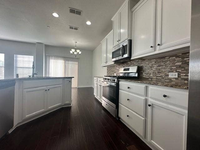 901 Brookville Court, Plano, TX 75074 Kitchen featuring white cabinetry, stainless steel appliances, mosaic tile backsplash, and dark wood-finish flooring