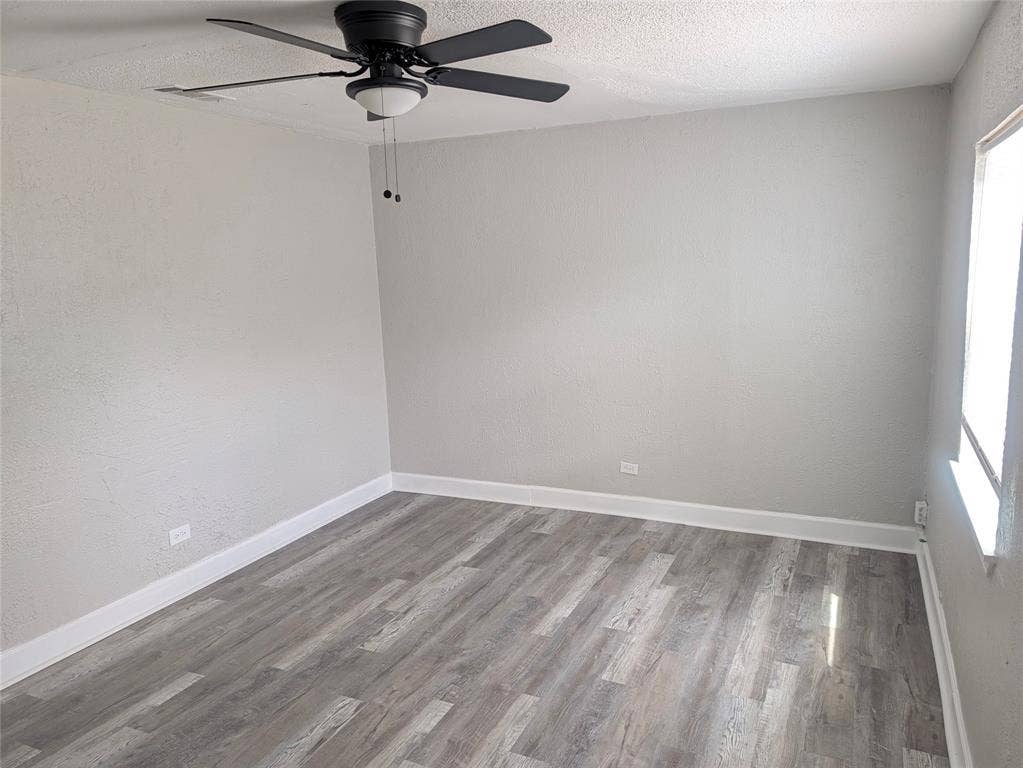 3409 Wood Avenue, Waco, TX 76711 Neutral wall paint, wood-finish flooring, and ceiling fan with integrated lighting