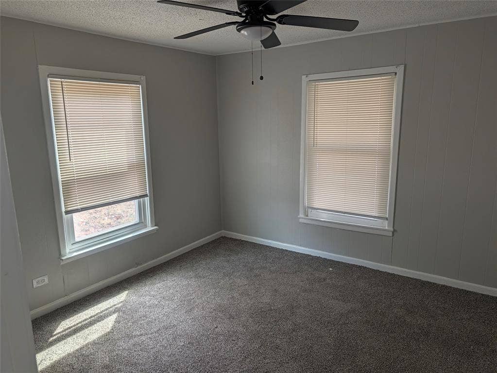3409 Wood Avenue, Waco, TX 76711 Wall-to-wall carpeting, two windows with blinds, paneling, and a ceiling fan