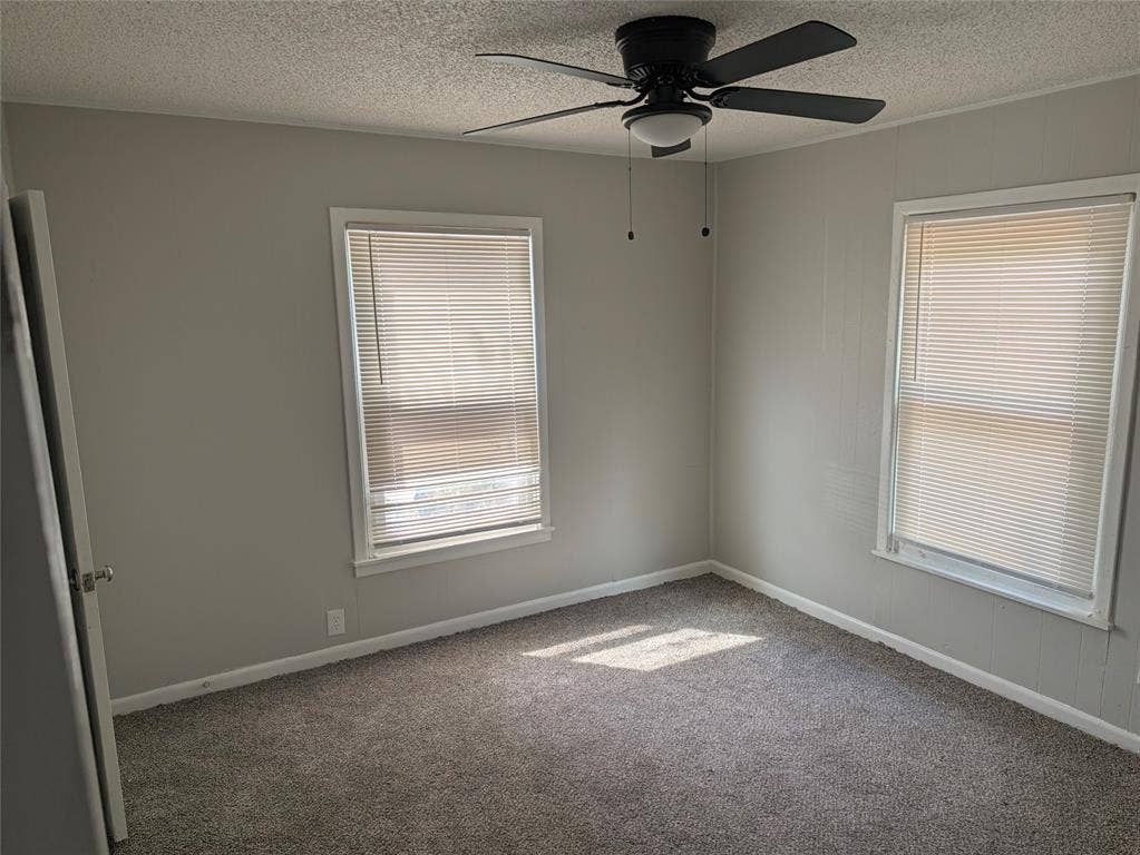 3409 Wood Avenue, Waco, TX 76711 Neutral-toned walls, ceiling fan with integrated lighting, two windows with blinds, and gray carpeting